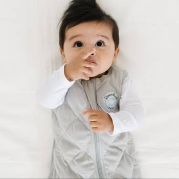 baby wearing the sleeveless sleep sack in gray