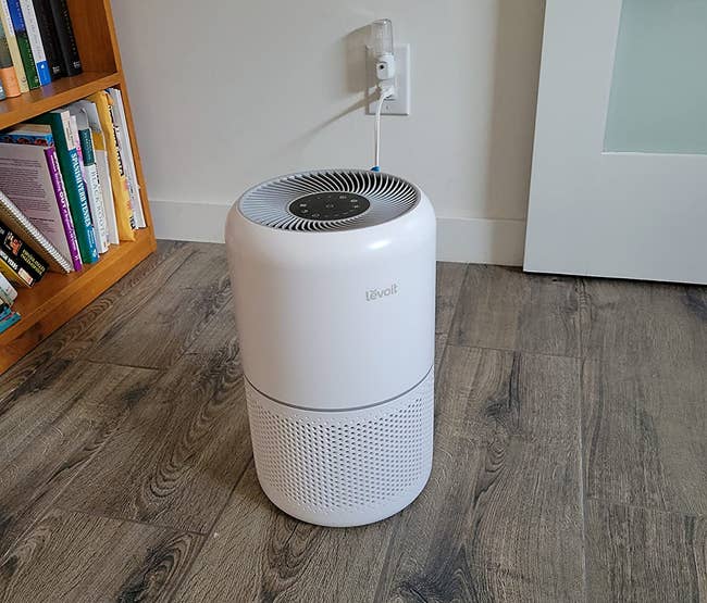 reviewer image of the white air purifier on a wooden floor