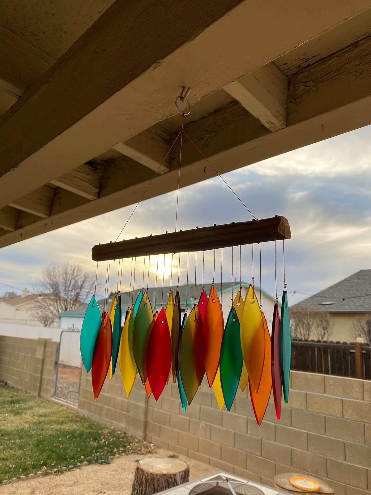 Colorful leaf-shaped upwind   chime hanging outdoors with sunset successful  the background