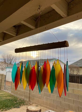 Colorful leaf-shaped upwind chime hanging outdoors with sunset successful the background