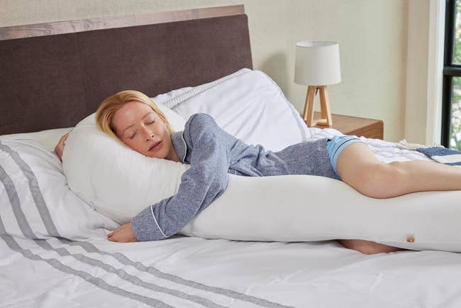 Person sleeping comfortably connected a bed, hugging a ample assemblage pillow