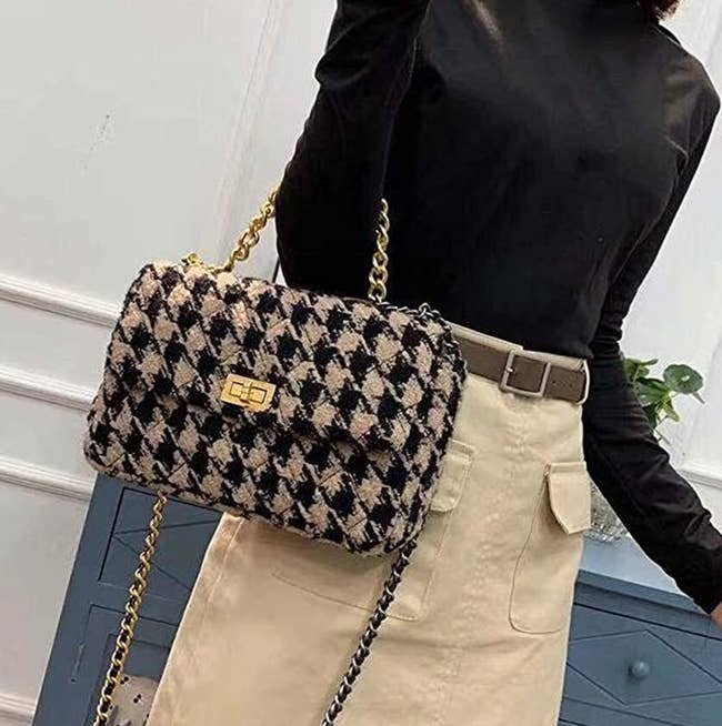 model using one of the long straps as a smaller arm strap to wear houndstooth bag