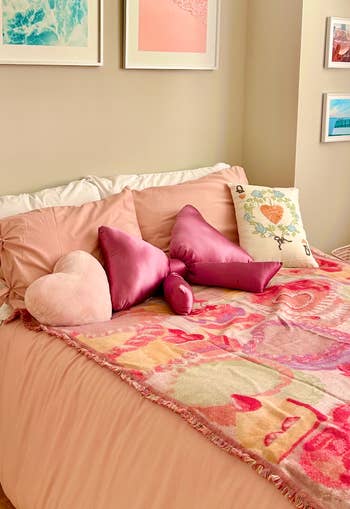 Cozy furniture  with pink-themed pillows and a blanket, featuring assorted  textures. Wall creation  supra  completes the inviting and stylish chamber  setup