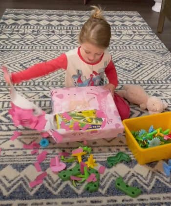 a child opening a present and confetti flying out of the paper
