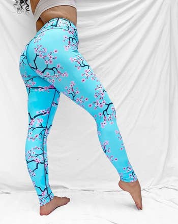 model in blue leggings with cherry blossom print on them
