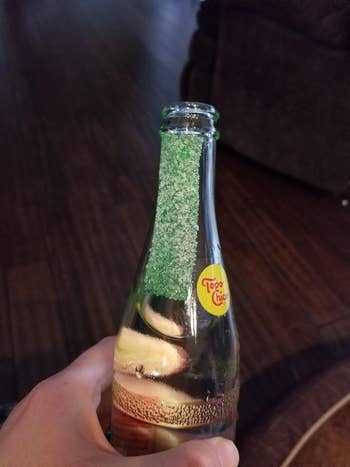 reviewer photo of the salt strip attached vertically to a topo chico water bottle