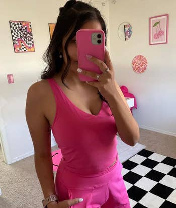 A person in a hot pink v-neck sports top