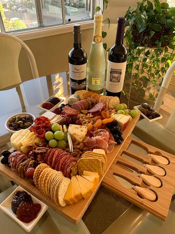 A reviewer's charcuterie board with a beautiful spread of meats, cheese, crackers and more on it