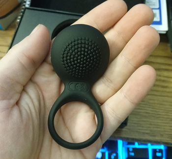 Reviewer displaying black textured side of cock ring