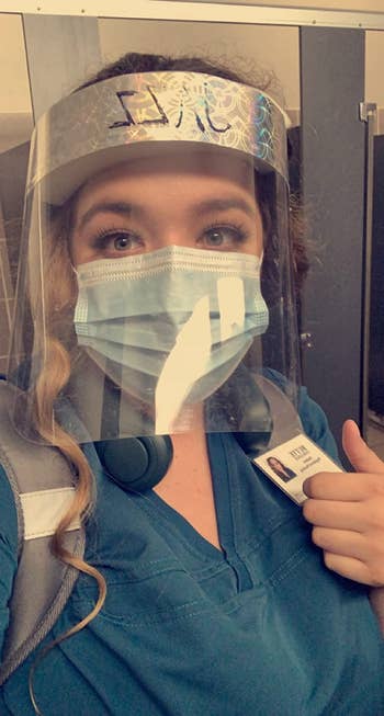 healthcare worker wearing the dark green fan around their neck with a mask and face shield