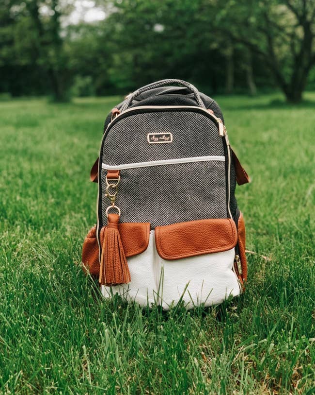 reviewer's photo of the diaper bag backpack on the grass
