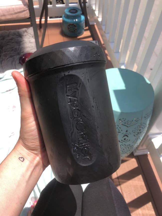 a reviewer holds the frozen black canister 