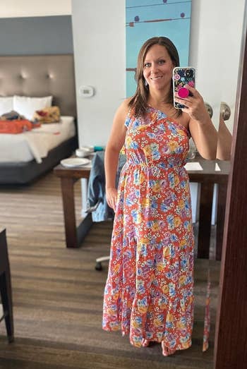 reviewer in a patterned maxi dress takes a mirror selfie, possibly suggesting a shopping or fashion context