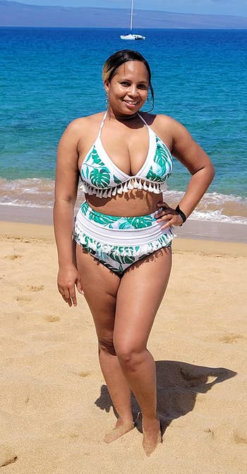Reviewer is wearing the tassle bikini set in a white and green tropical pattern