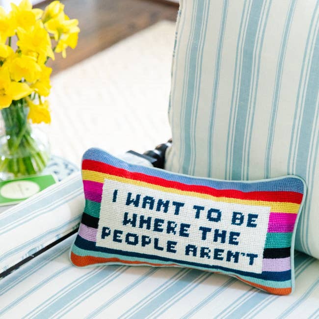 A rainbow-striped pillow that says 
