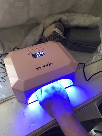 reviewer photo of hand inside uv nail lamp