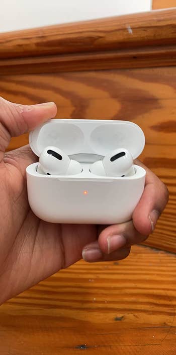 reviewer holding the AirPod Pros in their hand