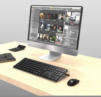 Desktop computer on a wooden table displaying a video editing software interface