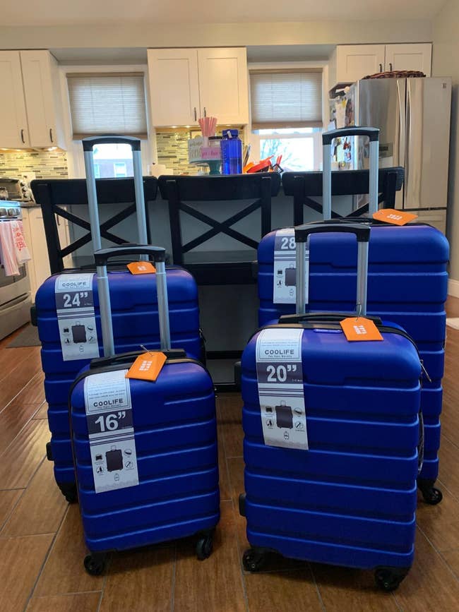 reviewer's four different sized suitcases in dark blue