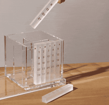 gif of hand placing the numbered calendar sticks into the pen holder along with pens and scissors