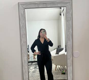 reviewer wearing black jumpsuit with tied waist