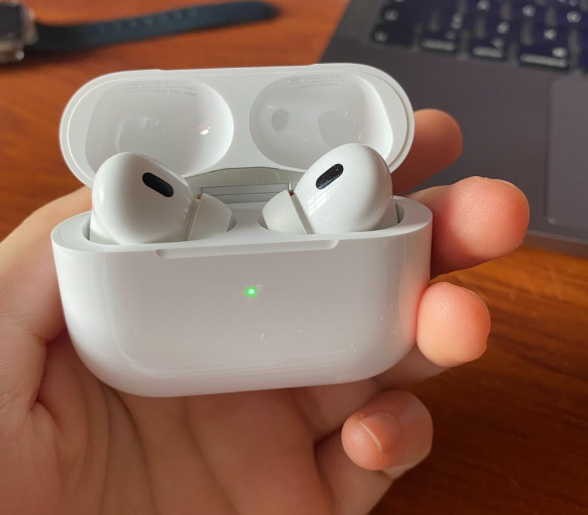 reviewer holding the airpods 