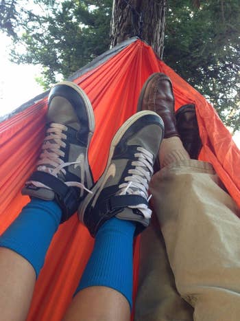 Reviewer and another person relaxing in their hammock, with just their shoes kicked back in the hammock showing