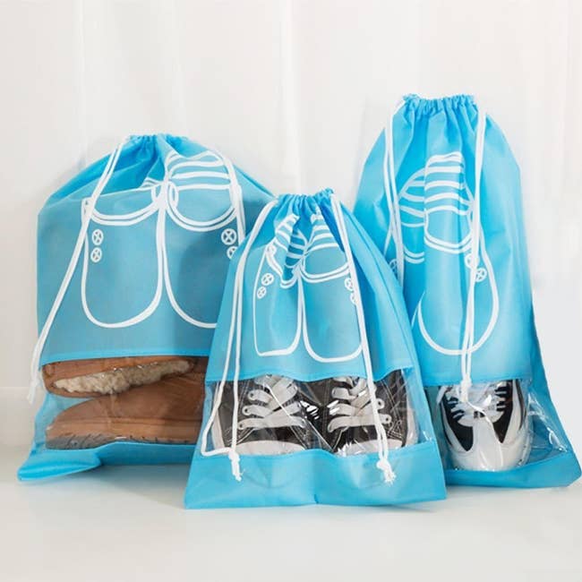 Three transparent drawstring storage bags with shoes inside
