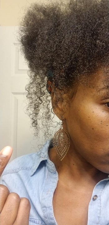 Reviewer with coily brown hair in a bun with a light denim top