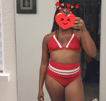 reviewer photo of them wearing a red and white tasseled bikini with a heart emoji covering their face