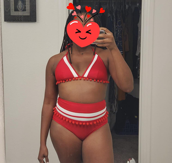 reviewer photo of them wearing a red and white tasseled bikini with a heart emoji covering their face
