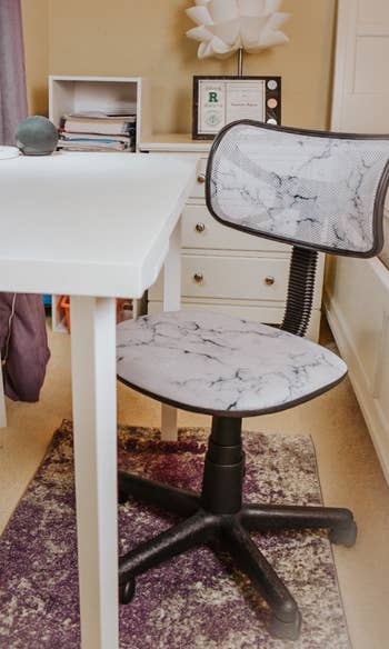 a reviewer photo of the desk featuring a white marble print in front of a desk 