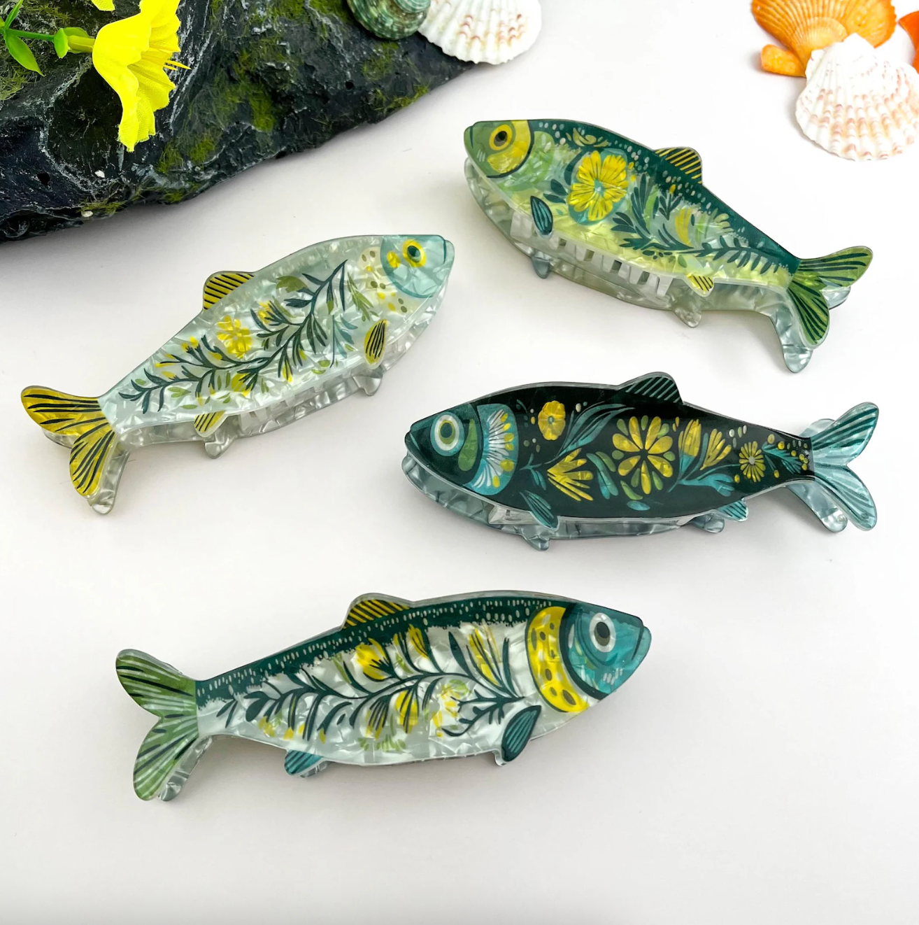 Four decorative fish-shaped clips with floral patterns displayed against a neutral background