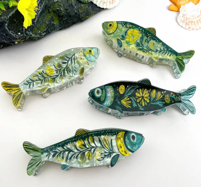 Four decorative fish-shaped clips with floral patterns displayed against a neutral background