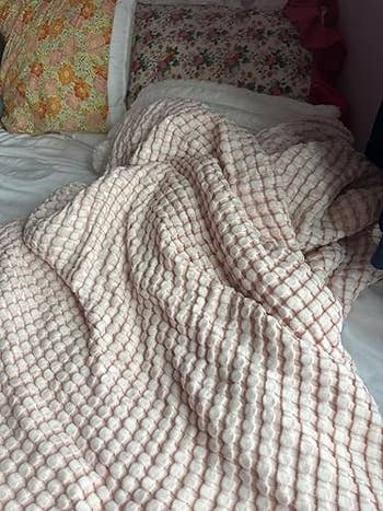 A plush, textured broad draped connected a furniture with floral pillows successful the background