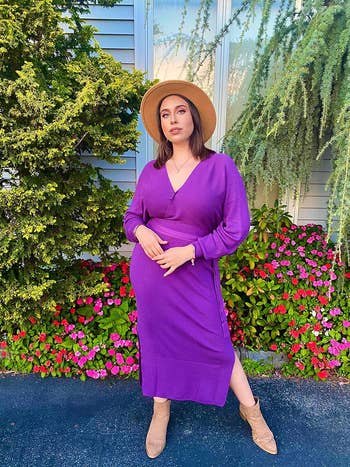 reviewer posing wearing purple v-neck dress