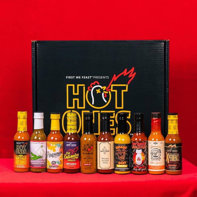 The lineup of the ten hot sauces included in the pack in front of the packaging box
