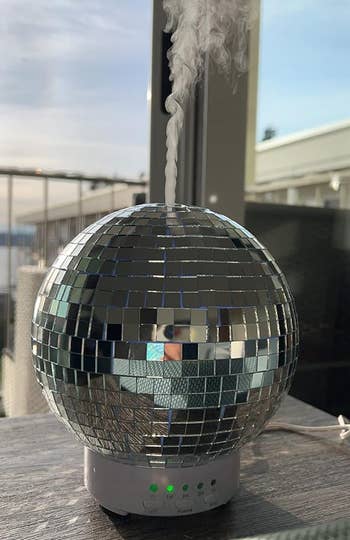 A disco ball-shaped humidifier with mist coming out