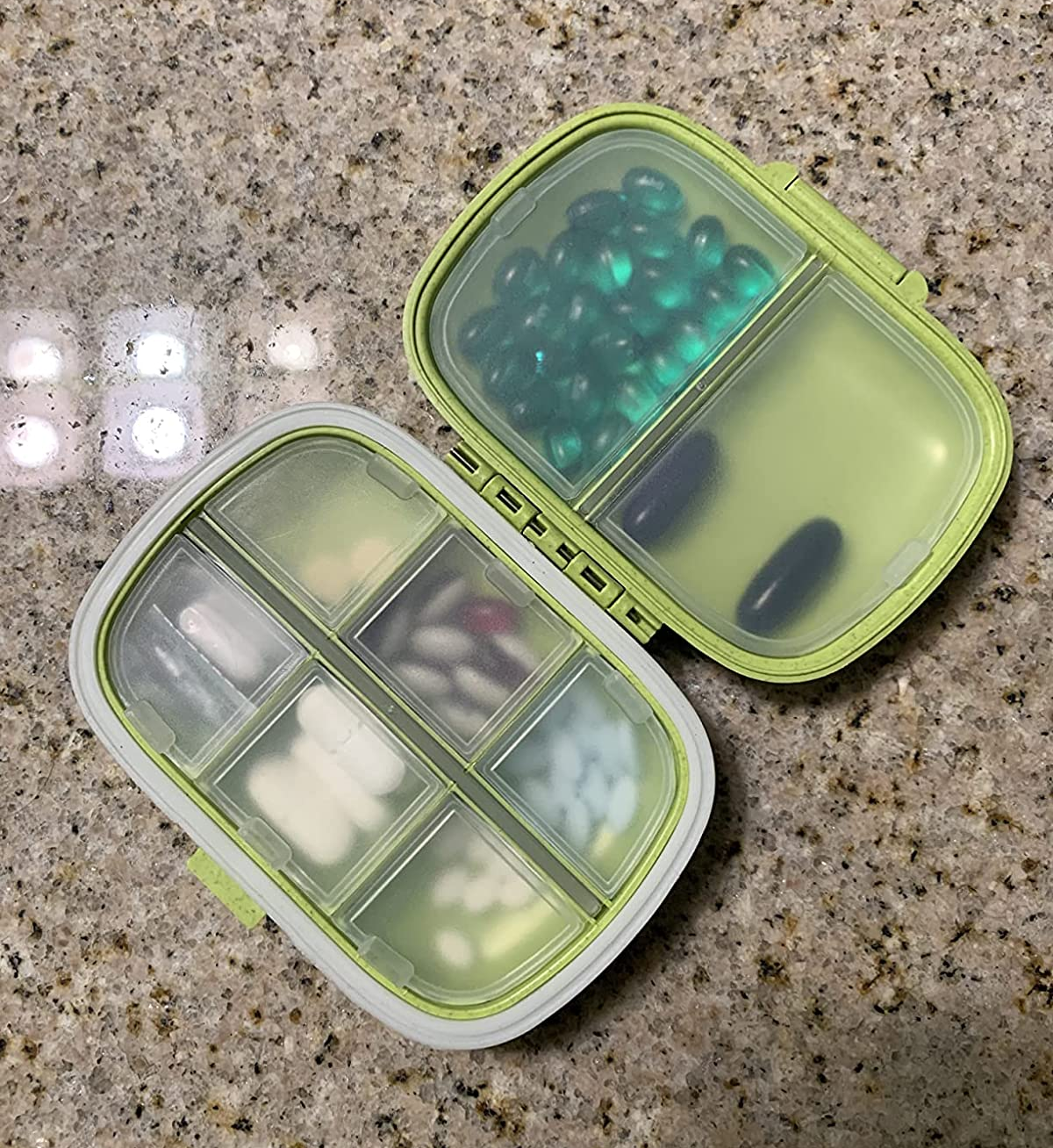 reviewer image of the pill organizer in green, full of different pills
