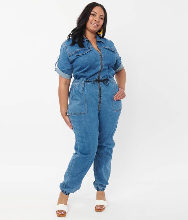 model in blue short sleeve jumpsuit with zipper down the front