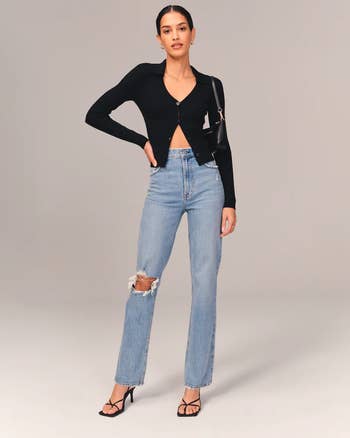model wearing the straight leg jeans with a ripped knee