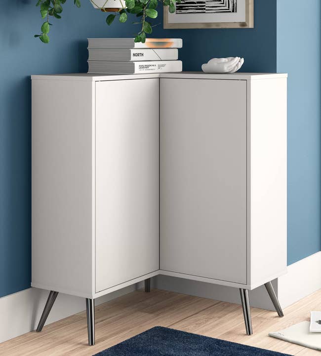 White L-shaped corner cabinet in front of blue wall