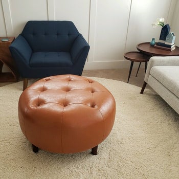 reviewer photo of cognac leather round tufted ottoman in living room