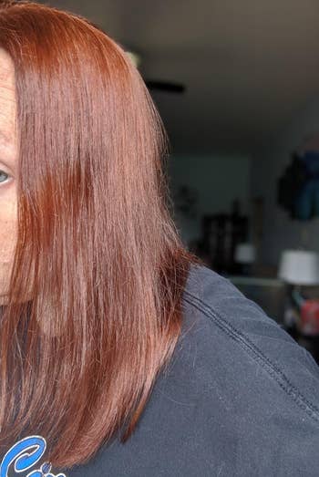 Reviewer image of red shiny hair with black top on