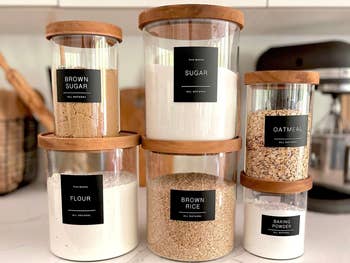 Kitchen shelf with labeled jars containing brown sugar, sugar, oatmeal, flour, brown rice, and baking powder