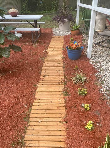a reviewer photo of the wooden pathway laid down in a garden surrounded by wood chips 