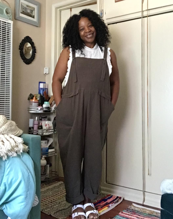 a plus size reviewer wearing the army green overalls