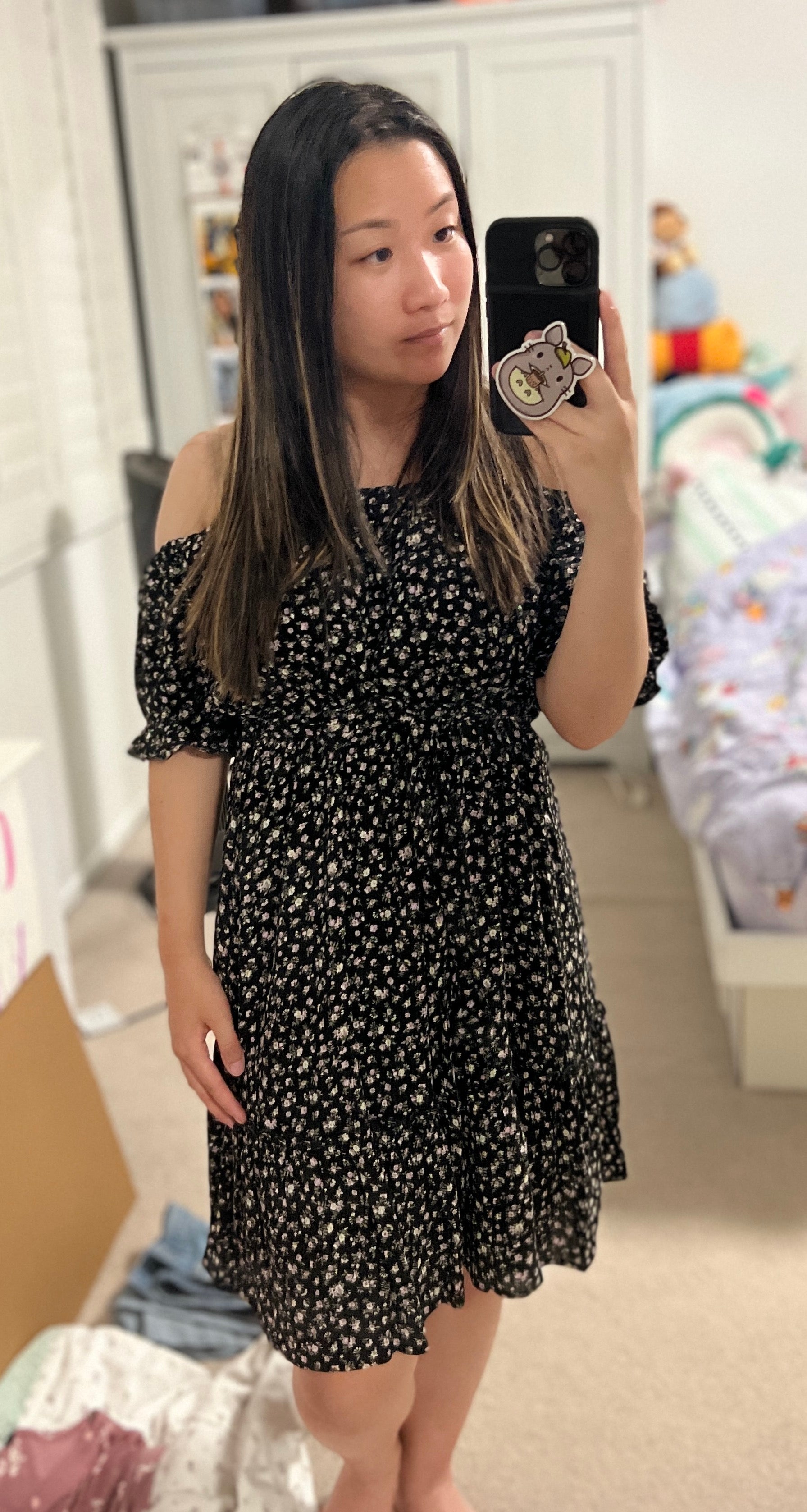 BuzzFeeder Brittney Trinh wearing a black floral-print off-shoulder ruffle dress from Short Story