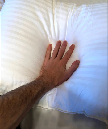 Reviewer pressing a hand into a pillow 