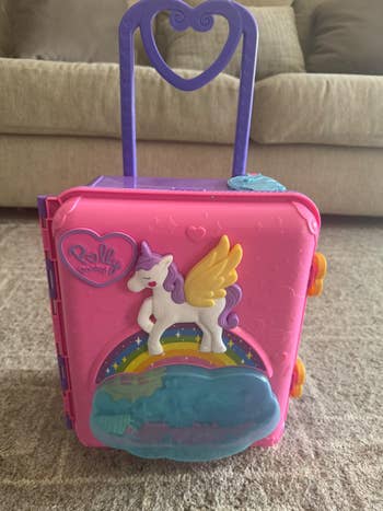 Children's artifact  suitcase with a unicorn plan  connected  the front, heart-shaped handle, and rainbow detail